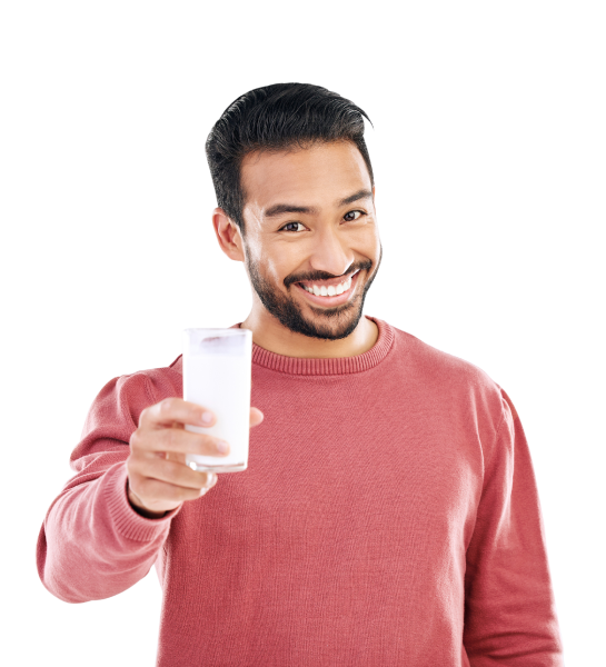 Persona con suéter rojo extendiendo un vaso de leche hacia la cámara, transmitiendo una sensación de ofrecimiento o invitación.